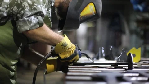 Close-up blacksmith welder in protective mask works with metal using a welding Stock Footage 139590577