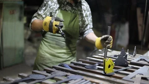 Close-up blacksmith welder in protective mask works with metal using a welding Stock Footage 139590637
