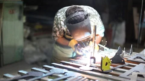Close-up blacksmith welder in protective mask works with metal using a welding Stock Footage 139590987