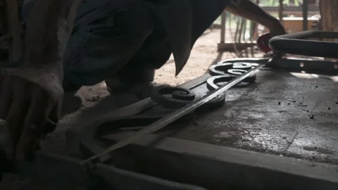 Close-up of a blacksmith's hands measuring a decorative grille in his worksho Stock Footage 253253045