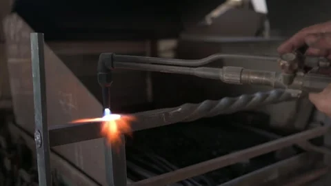 Close-up of a blacksmith's torch heating a rivet for a decorative grille in.. Stock Footage 253848016
