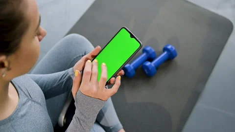 A close-up. Blank digital smartphone in hand of women in sportswear in bright Stock Footage 151280801
