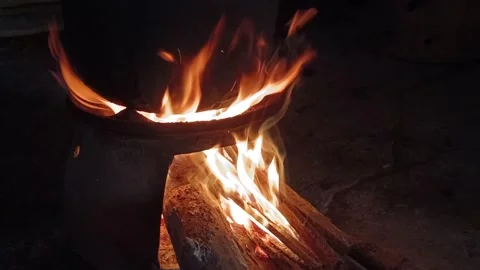 Close up of blazing fire burning firewood under a traditional clay stove at nigh Stock Footage 339831259