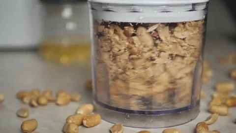 Close-up of a blender grinding roasted peanuts to make peanut butter. Breakfast  Stock Footage 272591673