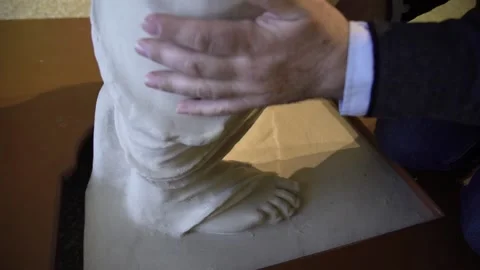 Close up of blind man's hands touching a replica of the Aphrodite de Milo at Stock Footage 148387262