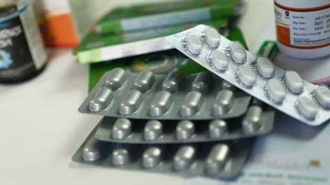 Close-up of blister packs of white tablets and capsules on a pharmacy count.. 库存影片 330547556