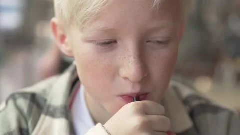 Close-up, a blond boy drinking a drink from a straw Stock Footage 224714952