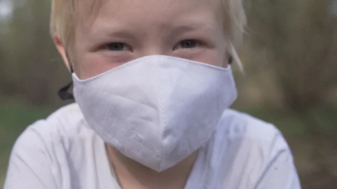Close-up of a blond boy in a protective medical mask Stock Footage 129732380