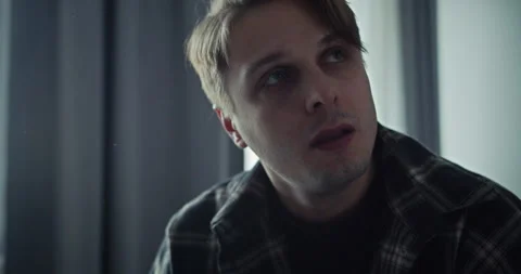 Close-up a blond guy is tired and trying to exhale after a family quarrel at Video stock 305774929
