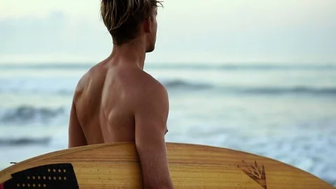 Close up of a blonde surfer guy walk on beach holding surfboard.  Healthy Active Video stock 108565224