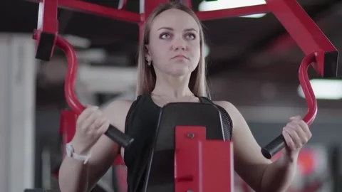 Close up of blonde woman does exercise on Strength Trainer machine at gym Video stock 143518829