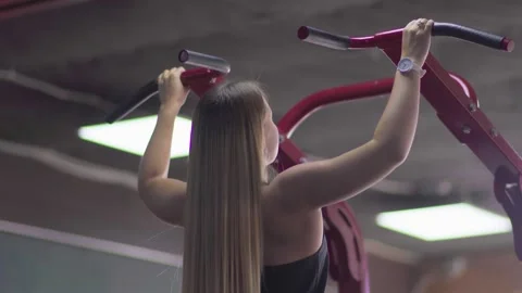 Close up of blonde woman pulls up on the horizontal bar. Training with Stock Footage 143516480