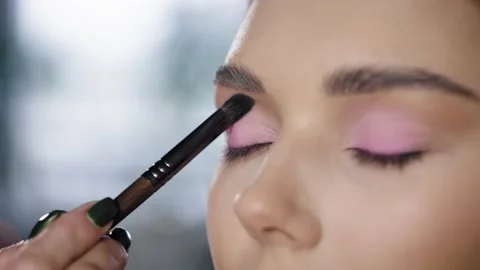 Close-up of a blonde woman's face getting her make-up done. The make-up artist Stock Footage 236117245