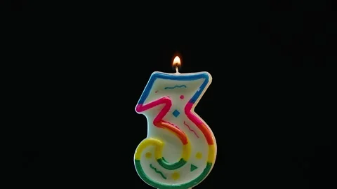 Close up of blowing out candle with number 3 on black background in slow motion Stock Footage 247438280