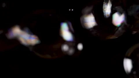 Close up blowing soap bubbles in slow motion on black background. Stock Footage 146894640