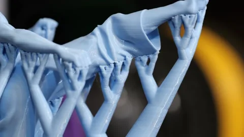 Close-up of a blue 3D printed character figurine with delicate tree support Stock Footage 344922076