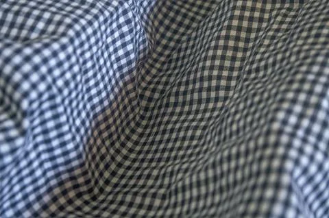Close up on a blue and white gingham fabric with soft folds, creating a tex.. Photos