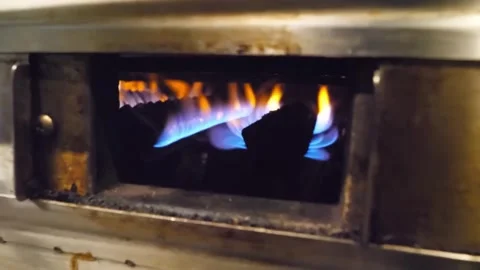Close-up of a blue and yellow flame igniting material inside a metal chamber, po Stock-Footage 332814600