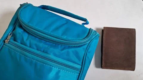 Close-up of a blue backpack with a brown wallet. Casual travel accessories for Stock Photos