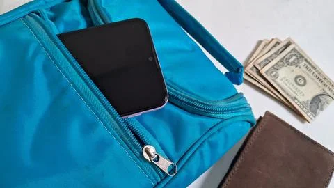 Close-up of a blue backpack with a smartphone and cash. Casual travel Stock Photos