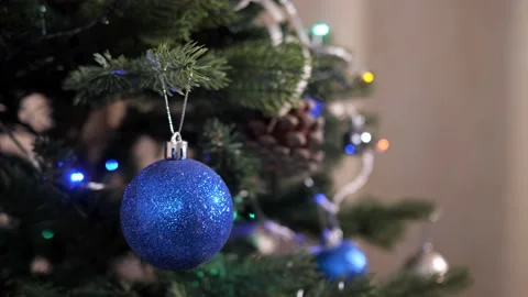 Close-up of blue ball and sparkling garland on artificial christmas tree Stock Footage 158486563