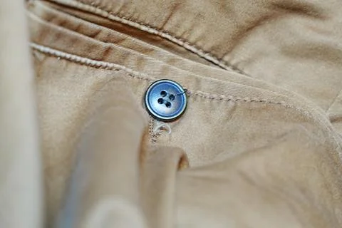 Close-up of a blue button on a fabric coat, emphasizing details like stitching Stock Photos