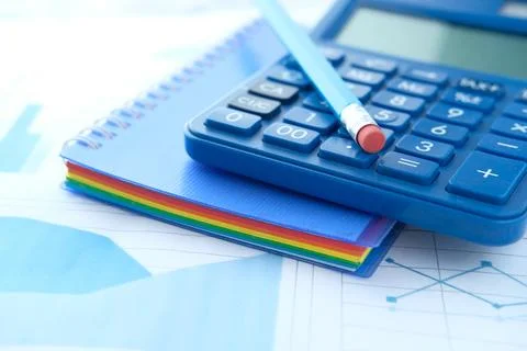 Close up of blue calculator and notepad on color background 写真素材