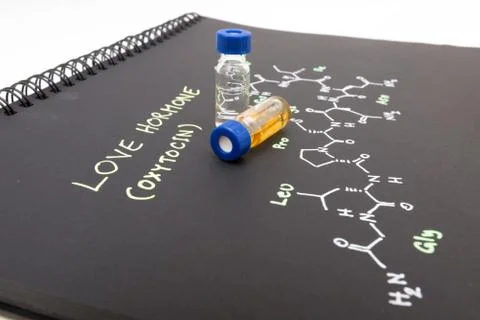 Close-up blue cap sample vial on notebook with chemical formula of Oxytocin.. Stock Photos