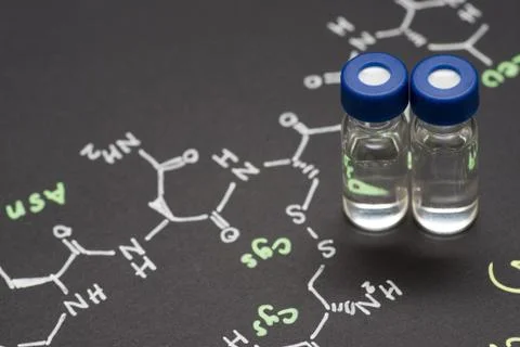 Close-up blue cap sample vial on paper with chemical formula of Oxytocin (l.. Stock Photos