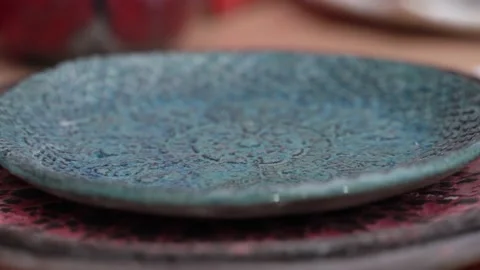 Close-up of a blue ceramic plate made by hand, which the girl strokes with her Stock Footage 194513248