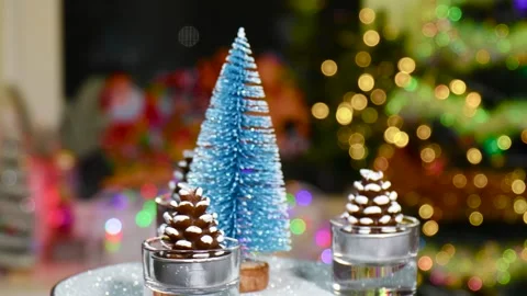 Close-up of a blue Christmas tree surrounded by pine cones rotating on a stand Stock Footage 260878752
