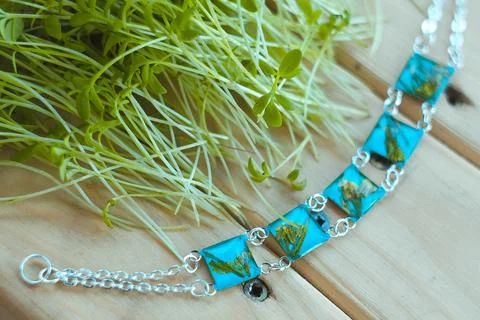 Close up blue craft bracelets with dry flowers near sprouts concept photo Stock Photos