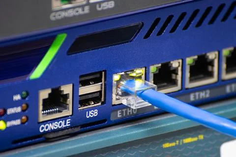 Close-up a blue ethernet cable into a network switch or router Stock Photos