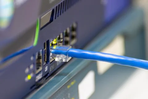 Close-up a blue ethernet cable into a network switch or router. Concept of .. Photos