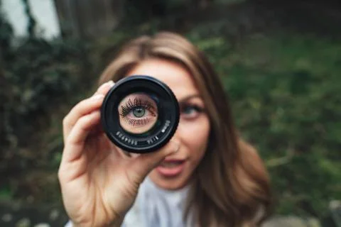 Close up of blue eye through a lense blonde hair Stock Photos