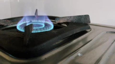Close up of a blue flame burning on a stainless steel domestic gas stove burner 스톡 동영상 328229645