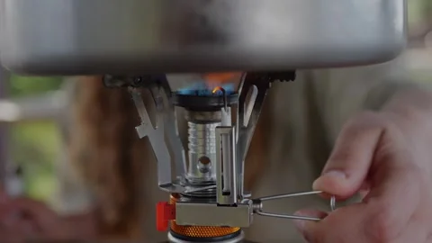 Close-up of blue flame heating metal pot on compact gas camping... Vidéo 322811605