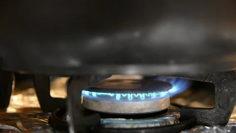 Close-up of blue flames under a burning oven stove top in kitchen cafeteria 動画素材 101078483