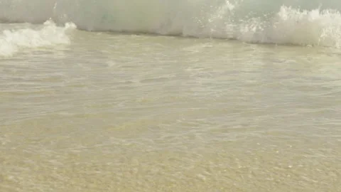 Close Up of Blue Foamy Ocean Waves Reaching Sandy Shore Slow Motion Видео 346105936