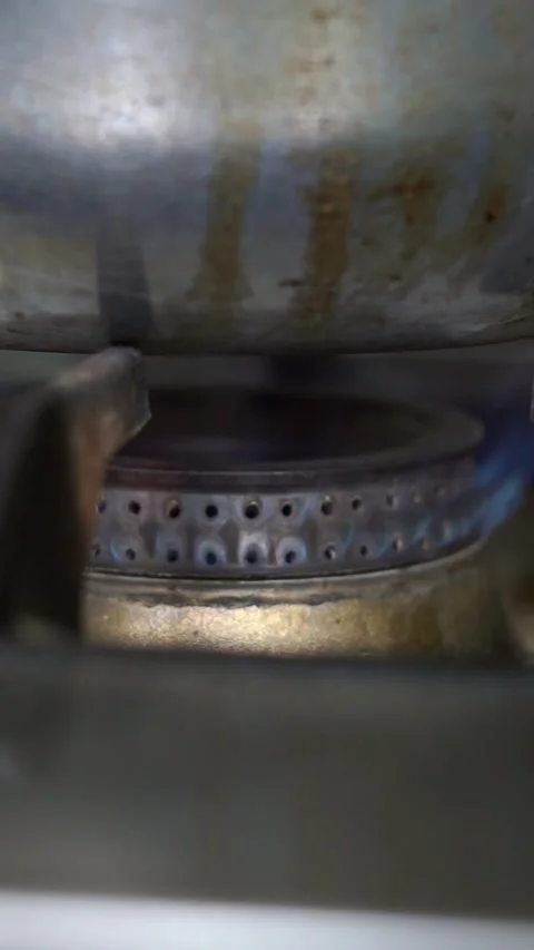 Close up of a blue gas flame burning on a commercial stove burner under a large  Stock Footage 341513953