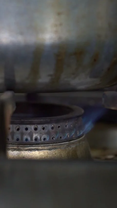 Close up of a blue gas flame burning on a commercial stove burner under a large  Stock Footage 341513964