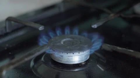 Close-up of blue gas flames burning on a stovetop burner. 60 fps Stock Footage 345395856