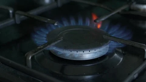 Close-up of blue gas flames burning on a stovetop burner. Slow motion Stock Footage 345396077