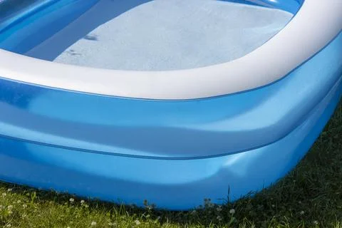 Close-up of a blue inflatable pool filled with clean cool water stands on the Stock Photos