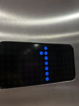 Close-Up Of Blue LED Indicator Dots With Number 1 On Black Digital Pane Foto stock