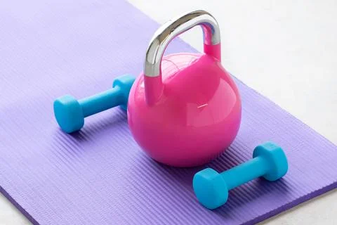 Close up of a blue light weights on a violet yoga pilates mat on the floor of a Stock Photos