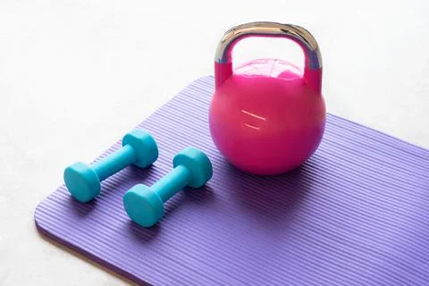 Close up of a blue light weights on a violet yoga pilates mat on the floor of a Foto stock