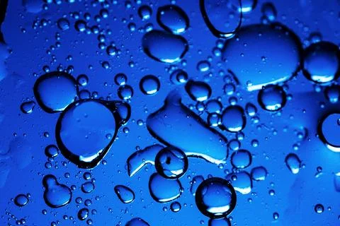 Close-up of blue liquid with bubbles, abstract background. Stock Photos