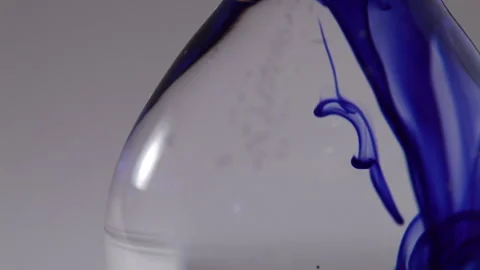 Close up of blue liquid going down throughout water on a flat bottomed flask Stock Footage 231488255