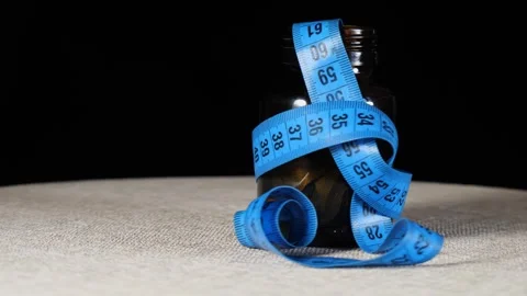 Close-up blue measuring tape inside medicine bottle rotating Video stock 277973024